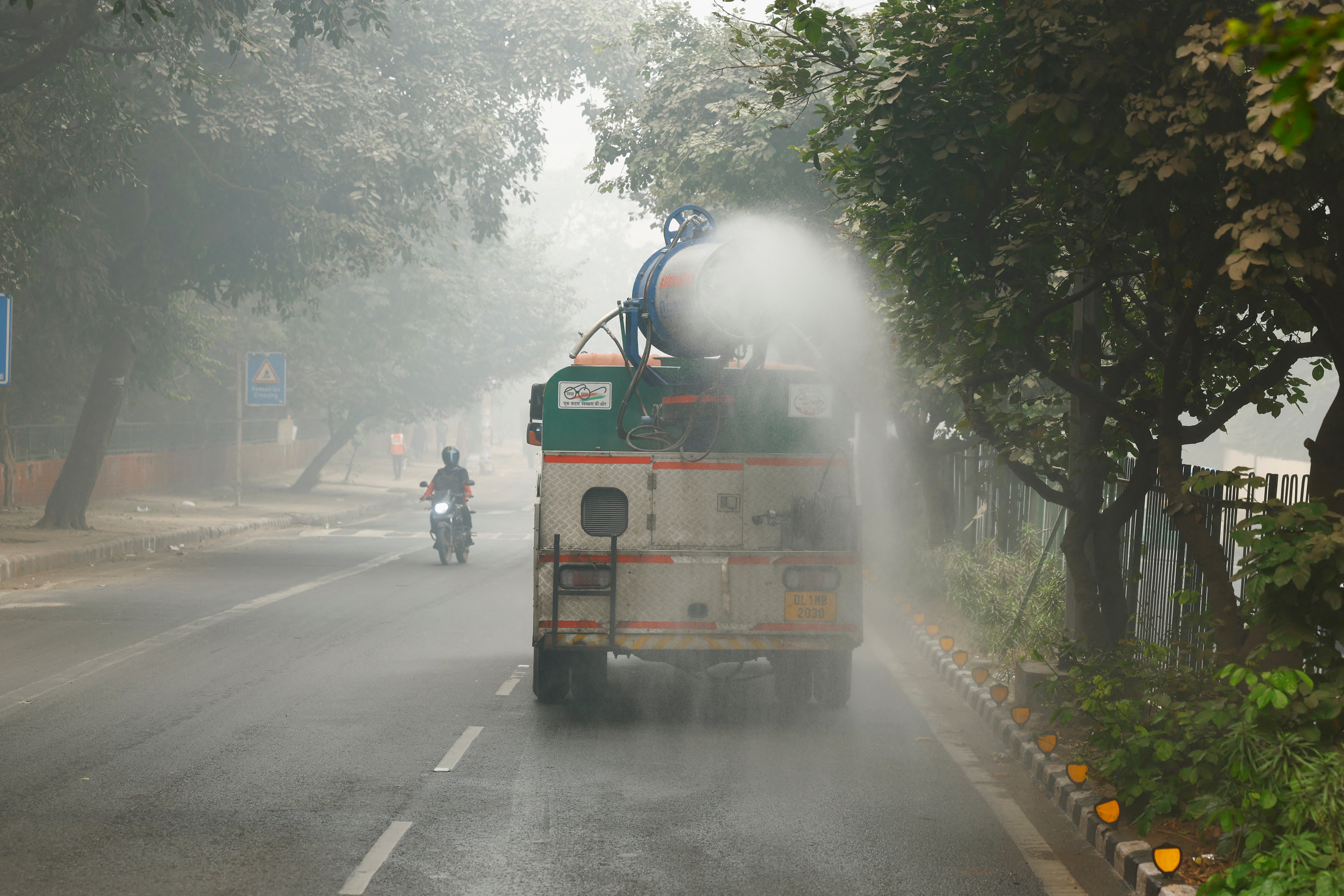 Illustration of a street dust control scenario in Delhi with a road sweeping machine and dust cleaning equipment