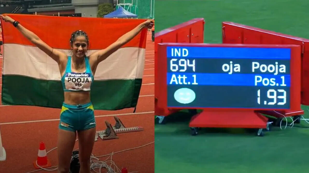 An athletics high-jump bar and landing mat in a stadium setting